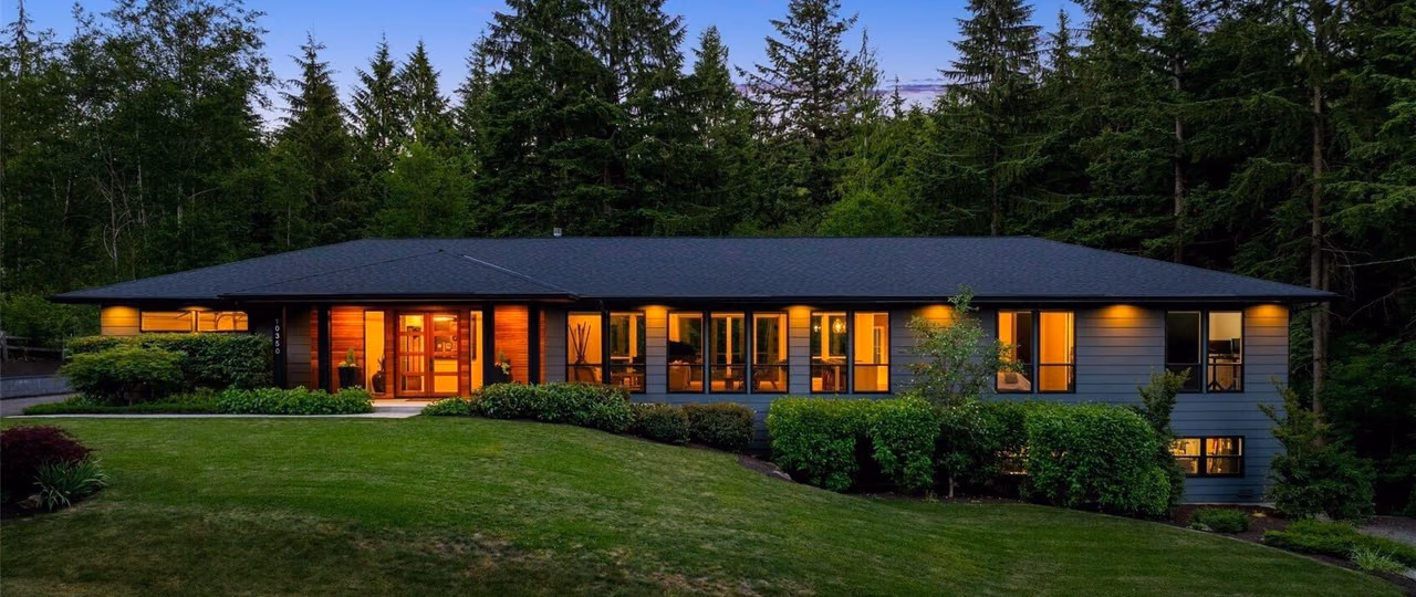 A multi-generational home at twilight in Snoqualmie, Washington, its windows lit